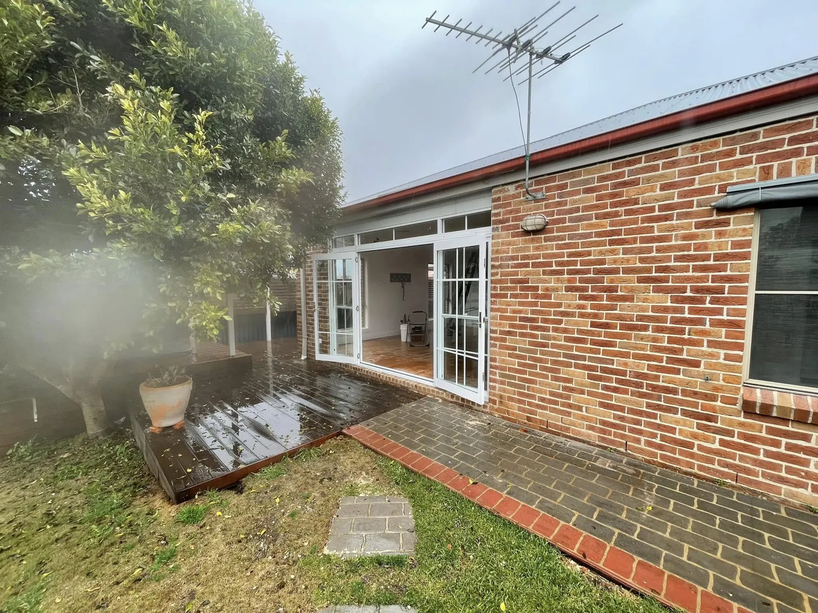 The patio enclosed with white-framed glass doors and windows