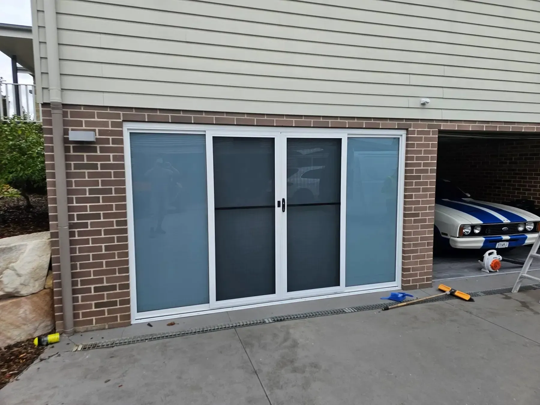 Garage front converted with an aluminium sliding glass door set into brickwork