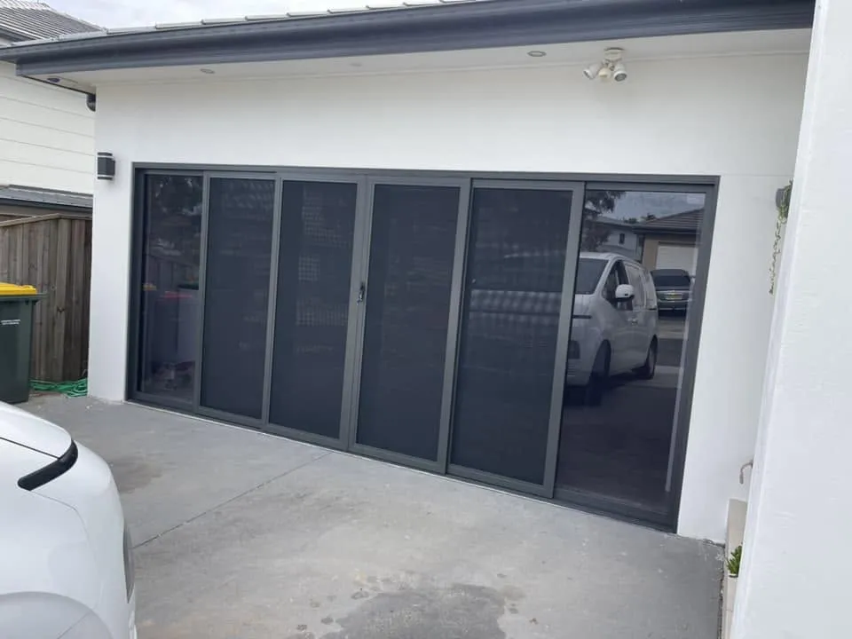 Black aluminium bifold doors fitted across a converted garage opening
