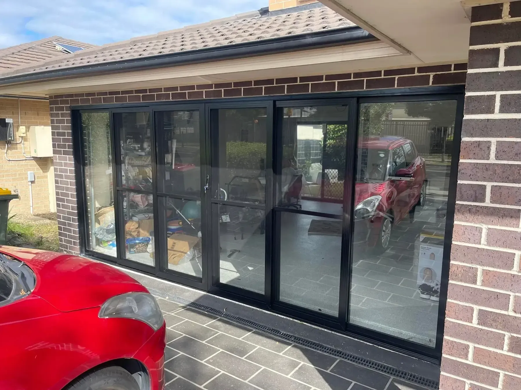 Black aluminium sliding glass doors across a converted garage opening