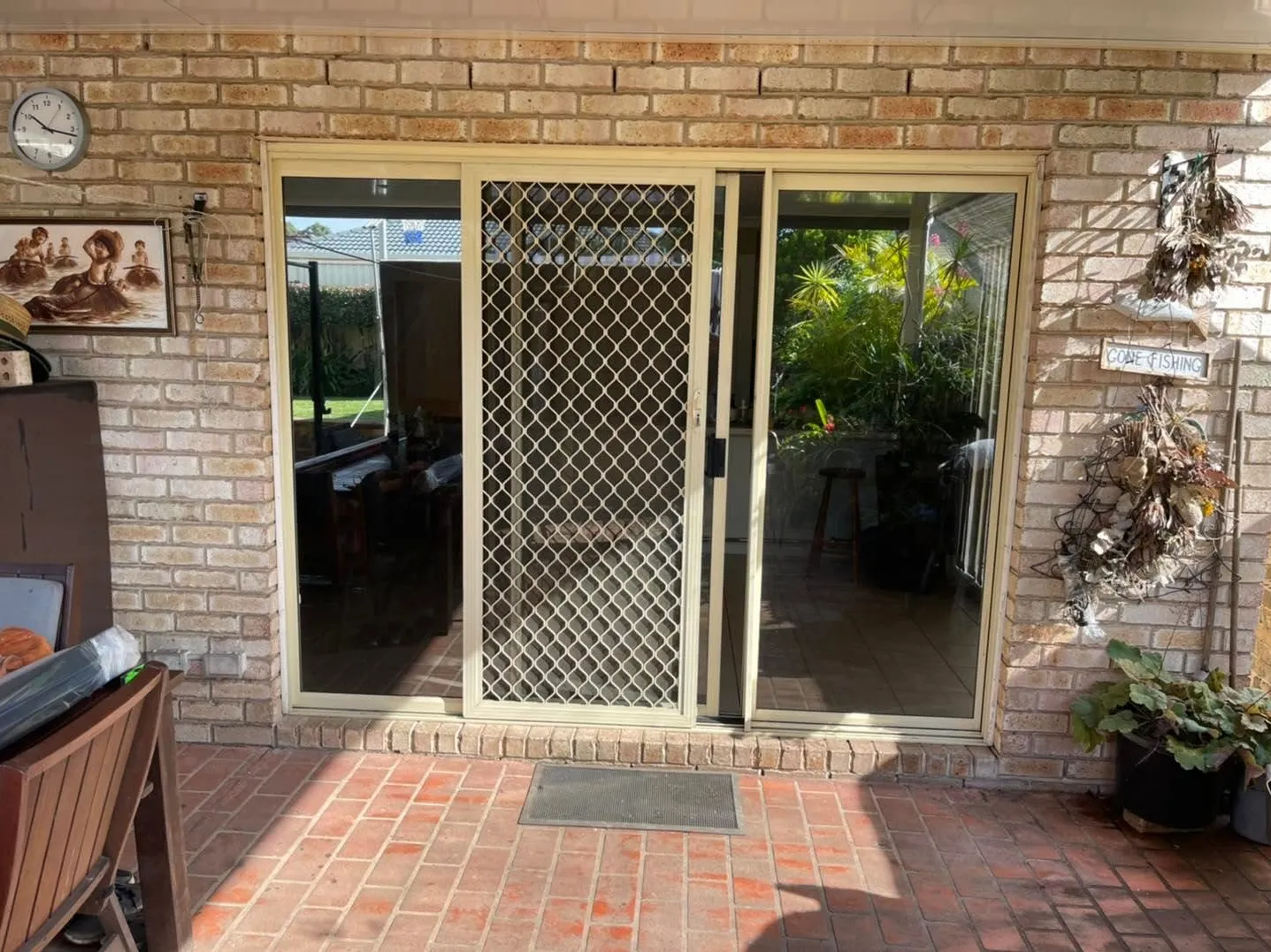 Brick patio entry with an old security screen door