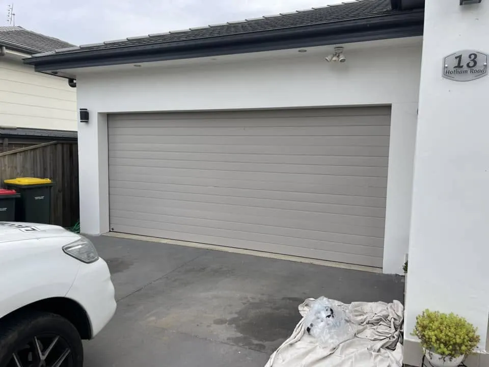 Garage with a grey roller door before a garage conversion